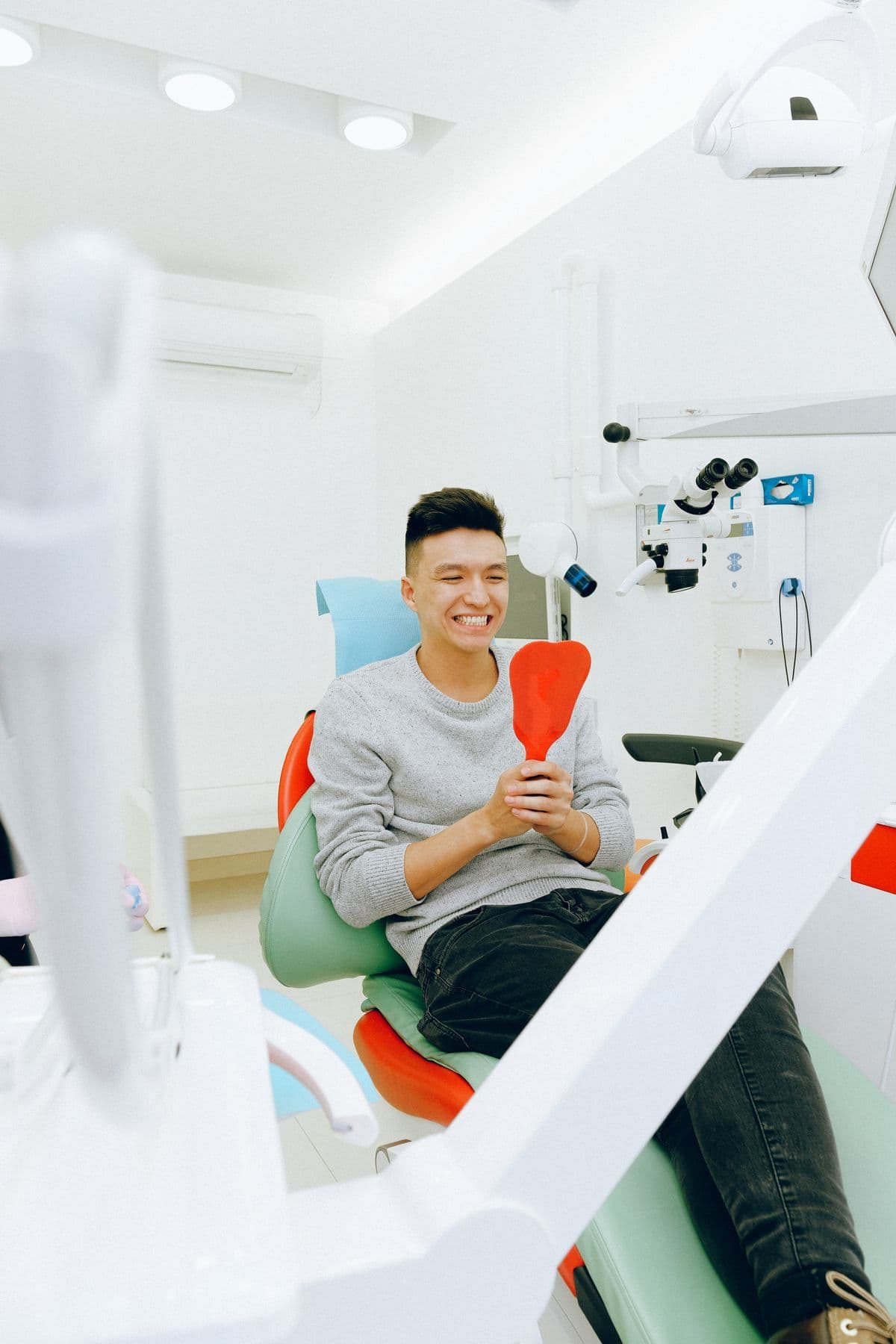 Bệnh nhân cười tươi trên ghế khám tại phòng khám nha khoa sáng sủa